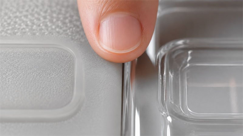 Side by side close up of matte silicone surface and glossy TPU surface with fingertip touch — material feel comparison